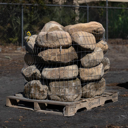 Stack of large stones wrapped in wire on a wooden pallet for sale near me