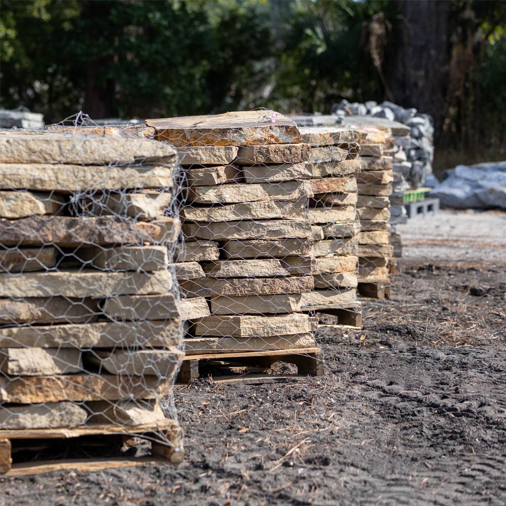 Stacks of stone slabs on pallets in an outdoor setting