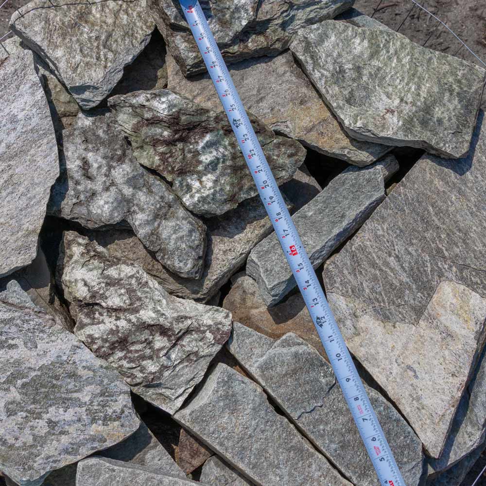 Pile of gray stones with a measuring tape for scale