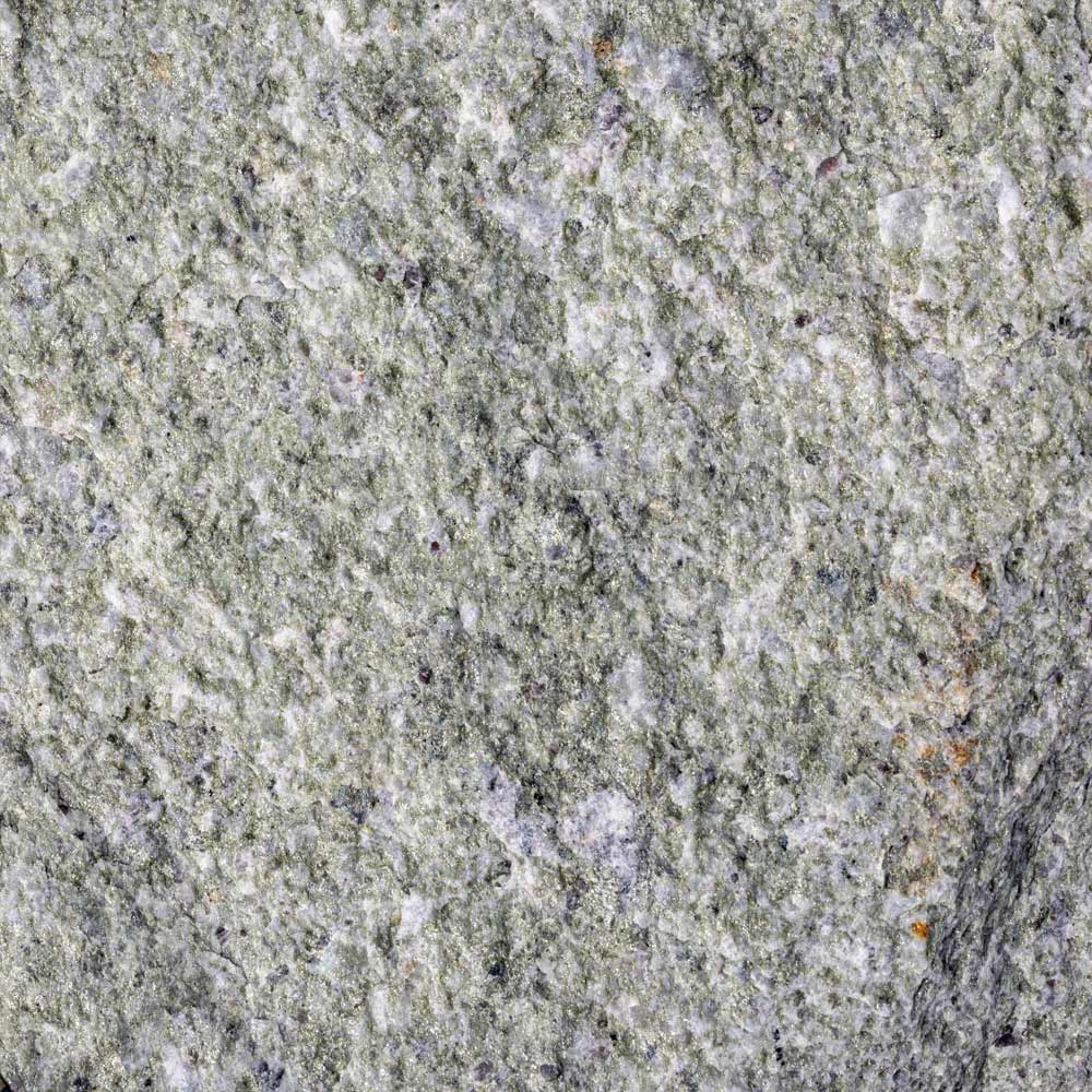 Close-up of a grayish-green stone surface with a rough texture